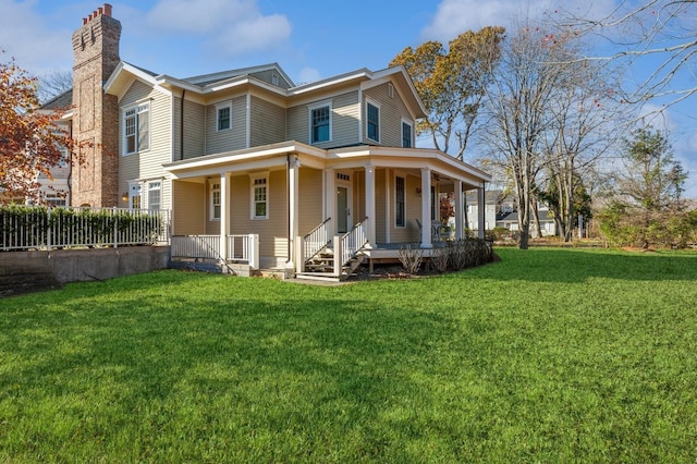 view of front facade with covered porch, a front lawn, and a chimney