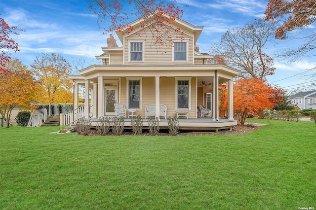 view of front of house featuring a porch, a chimney, a front yard, and a ceiling fan