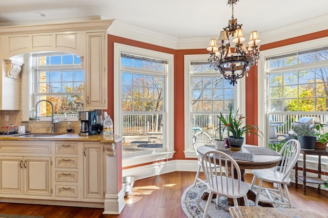 dining room featuring baseboards, ornamental molding, wood finished floors, and a notable chandelier