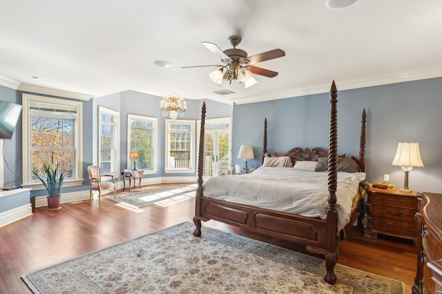 bedroom featuring wood finished floors, a ceiling fan, visible vents, baseboards, and ornamental molding