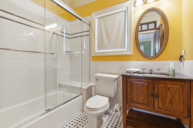 bathroom with a wainscoted wall, tile walls, toilet, and vanity