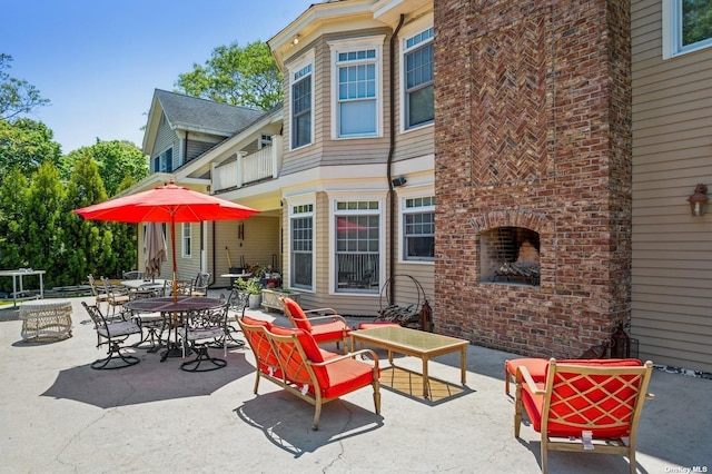 view of patio / terrace featuring an outdoor brick fireplace and outdoor dining space