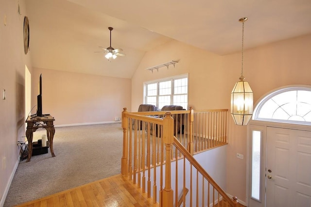 foyer entrance with wood finished floors, baseboards, lofted ceiling, ceiling fan, and carpet flooring