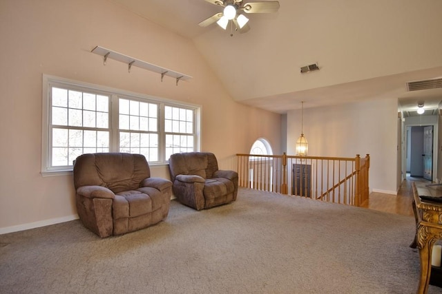 living area featuring an upstairs landing, visible vents, and carpet