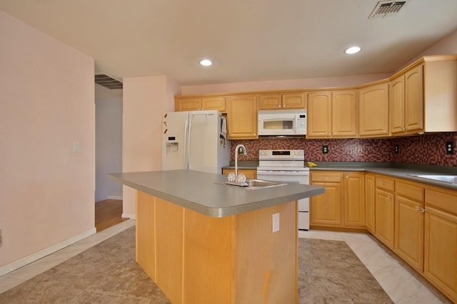 kitchen with light brown cabinets, visible vents, white appliances, and a sink