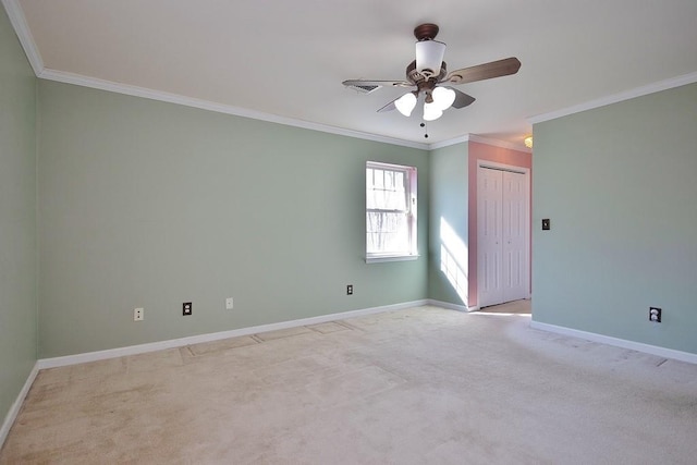 empty room featuring ceiling fan, baseboards, light colored carpet, and ornamental molding