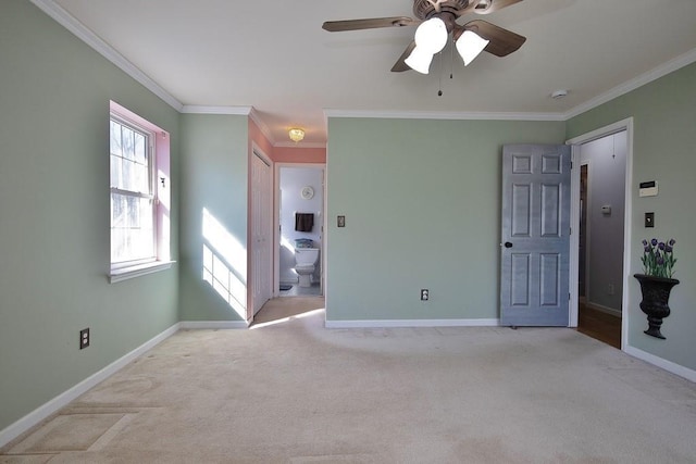 unfurnished bedroom with crown molding, baseboards, and carpet floors