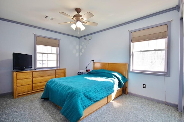 carpeted bedroom with a ceiling fan, crown molding, baseboards, and visible vents