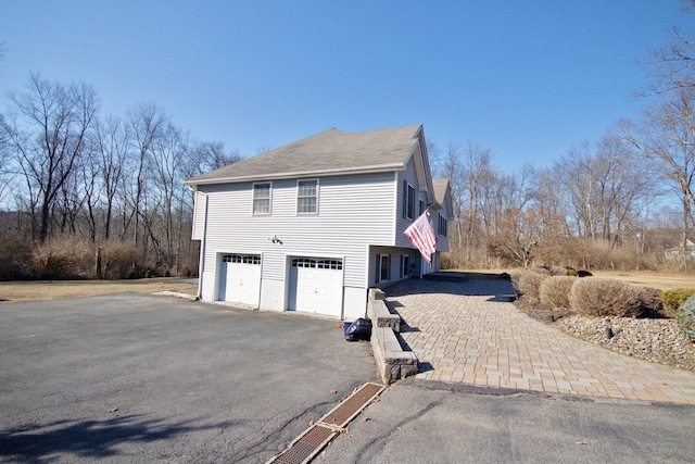 view of side of property featuring an attached garage and driveway