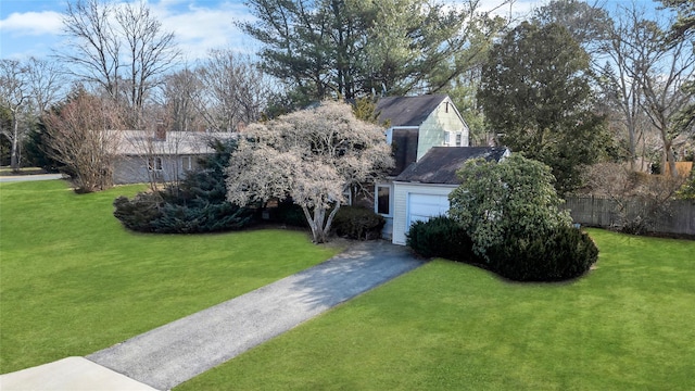 view of front of property with a garage, fence, aphalt driveway, and a front yard