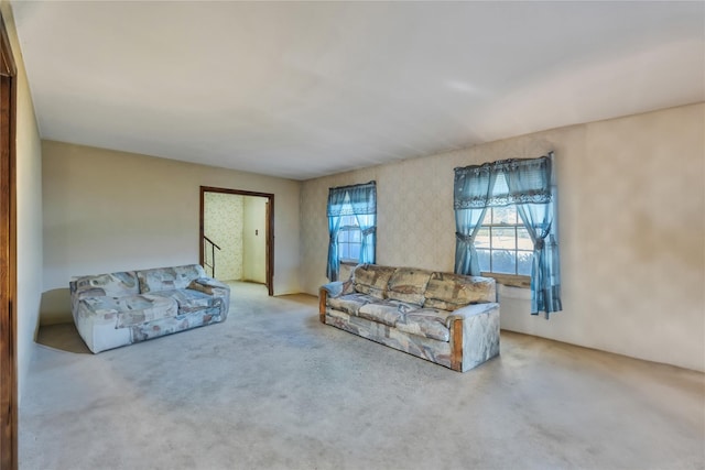 carpeted living area with stairs