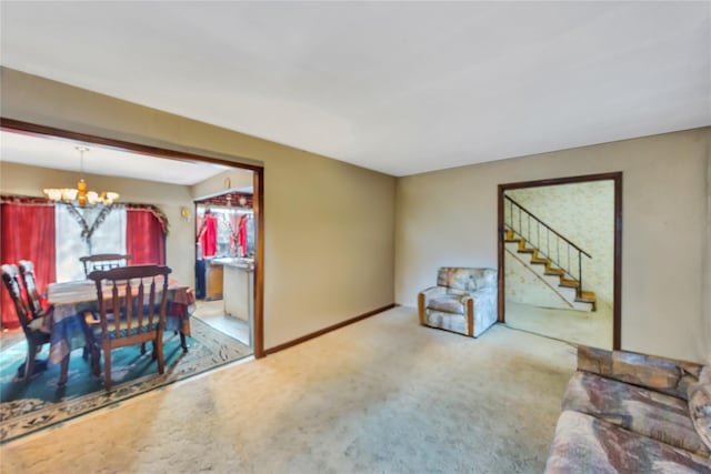 living room featuring carpet, stairs, baseboards, and a notable chandelier