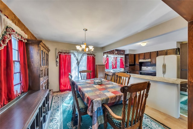 dining area with an inviting chandelier and wood finished floors