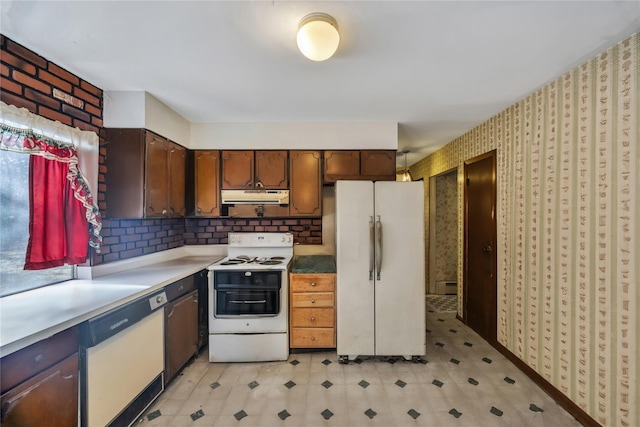 kitchen featuring white appliances, decorative backsplash, light floors, light countertops, and under cabinet range hood