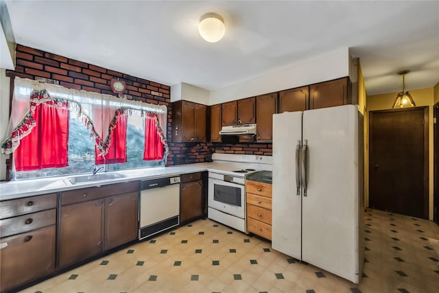 kitchen featuring light floors, a sink, dark brown cabinets, white appliances, and under cabinet range hood