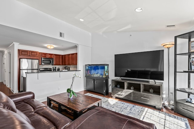 living room with visible vents, wood finished floors, and recessed lighting