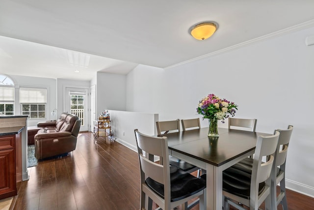 dining space featuring dark wood-style floors, baseboards, and ornamental molding