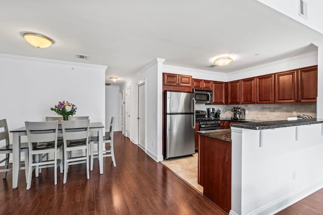 kitchen with tasteful backsplash, visible vents, a peninsula, stainless steel appliances, and crown molding