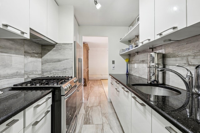 kitchen with stainless steel range with gas cooktop, white cabinetry, a sink, and open shelves