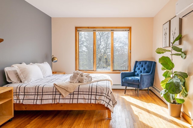 bedroom featuring an AC wall unit and hardwood / wood-style flooring