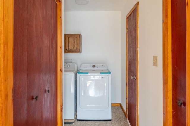 laundry area with baseboards, cabinet space, and independent washer and dryer