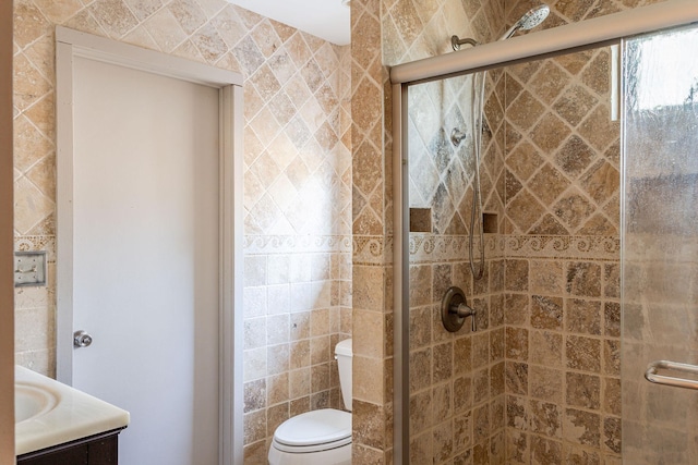 bathroom featuring vanity, a shower stall, and toilet