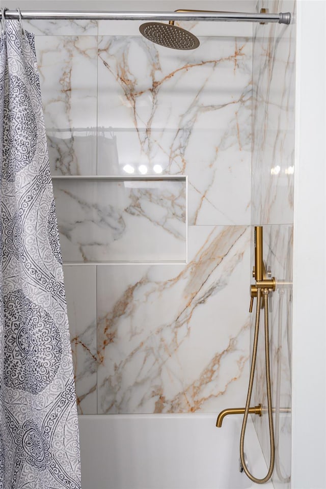 details featuring a marble finish shower and a washtub