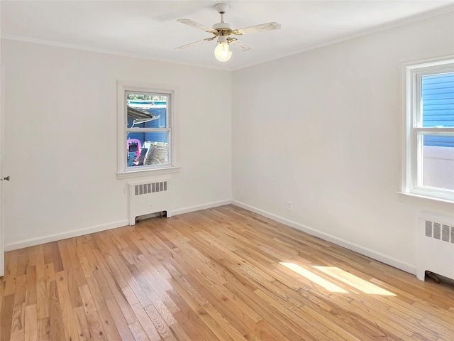 unfurnished room with baseboards, light wood-style flooring, and radiator