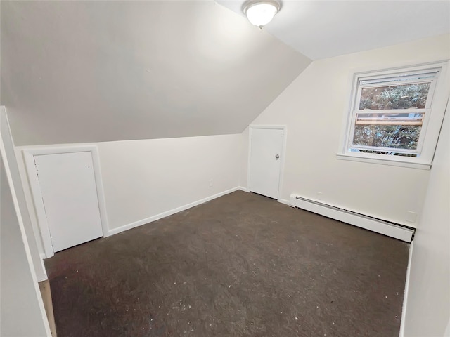 additional living space featuring baseboards, vaulted ceiling, and baseboard heating