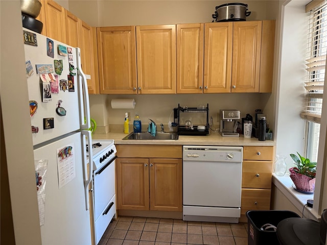 kitchen with white appliances, light countertops, a sink, and light tile patterned floors