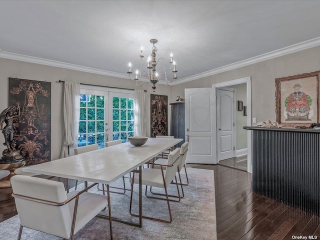 dining space featuring baseboards, wood-type flooring, an inviting chandelier, crown molding, and french doors