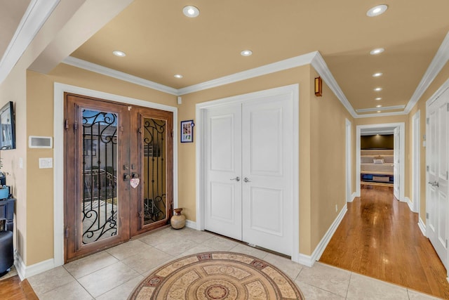 foyer entrance featuring light tile patterned floors, ornamental molding, and recessed lighting