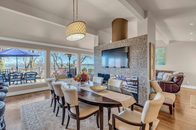 dining room with lofted ceiling, recessed lighting, wood finished floors, and baseboards