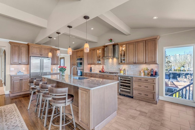 kitchen featuring lofted ceiling with beams, beverage cooler, stainless steel appliances, a sink, and wall chimney range hood