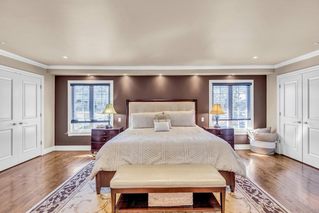 bedroom with light wood-style floors, baseboards, and ornamental molding