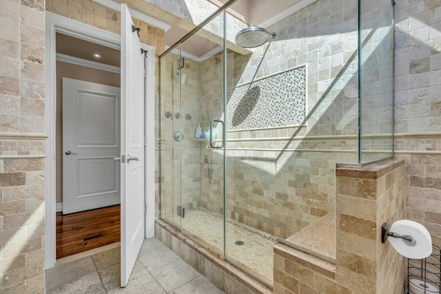 full bath with ornamental molding, a stall shower, and stone tile flooring