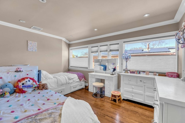 bedroom featuring ornamental molding, multiple windows, light wood-type flooring, and visible vents