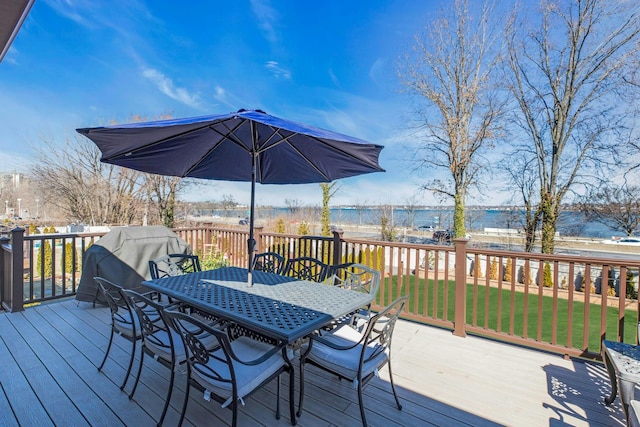 wooden terrace featuring outdoor dining area and a yard