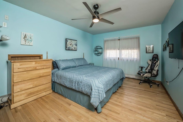 bedroom featuring light wood finished floors, baseboards, and ceiling fan