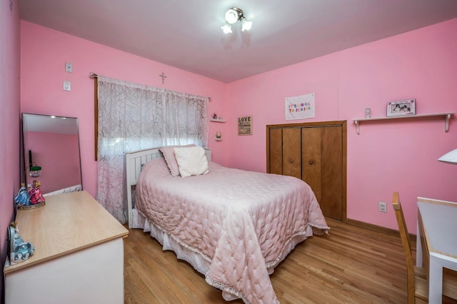 bedroom featuring baseboards and wood finished floors