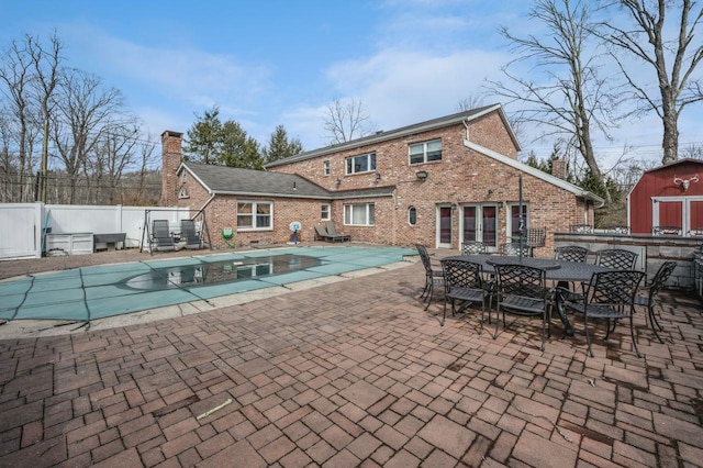 view of pool with fence, a fenced in pool, an outdoor structure, french doors, and a patio area