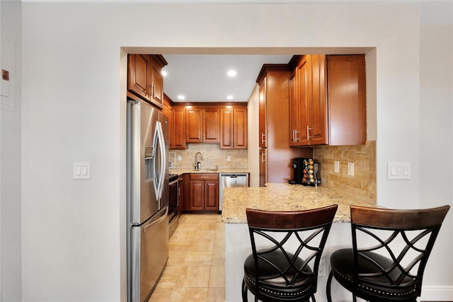 kitchen with stainless steel appliances, a breakfast bar, a peninsula, and decorative backsplash