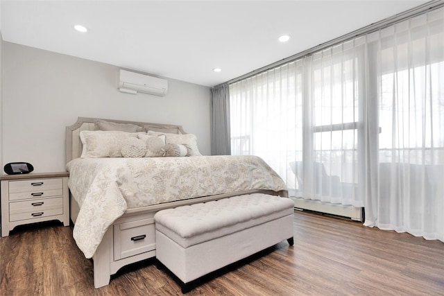 bedroom featuring recessed lighting, dark wood-style floors, a baseboard radiator, and a wall mounted air conditioner