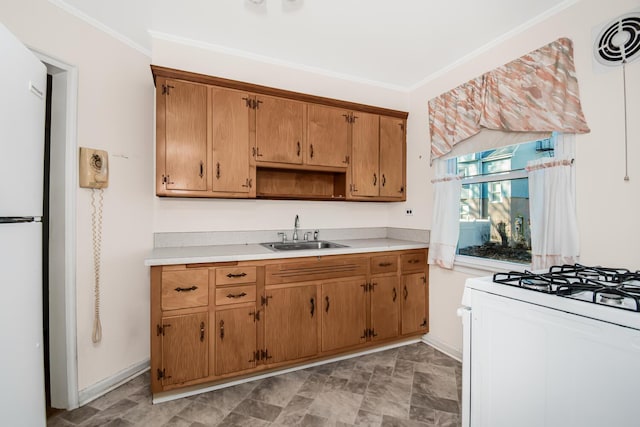 kitchen with crown molding, light countertops, visible vents, a sink, and white appliances