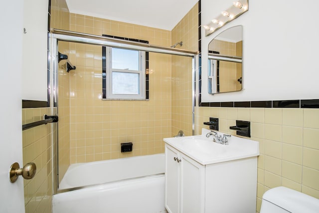 full bath with vanity, tile walls, toilet, and bathing tub / shower combination