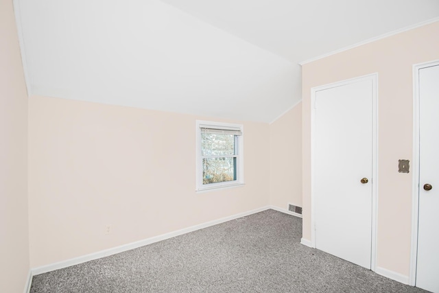 additional living space with carpet floors, visible vents, baseboards, and lofted ceiling