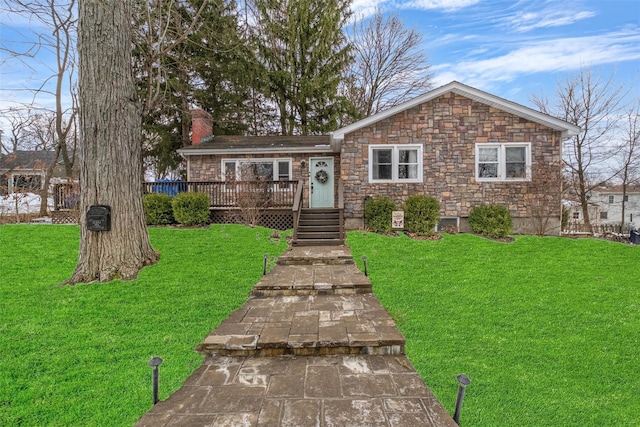 view of front of house featuring a deck, a chimney, and a front lawn