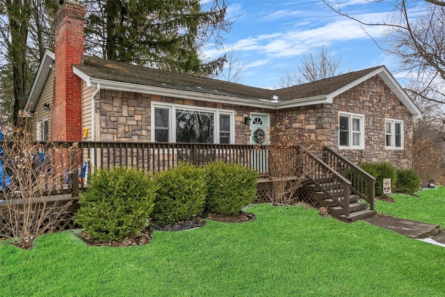 ranch-style house with a deck, stone siding, a chimney, and a front lawn