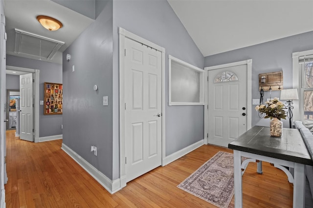 entryway featuring vaulted ceiling, light wood-type flooring, and baseboards