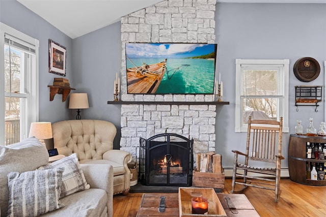 sitting room featuring a wealth of natural light, a fireplace, lofted ceiling, and wood finished floors